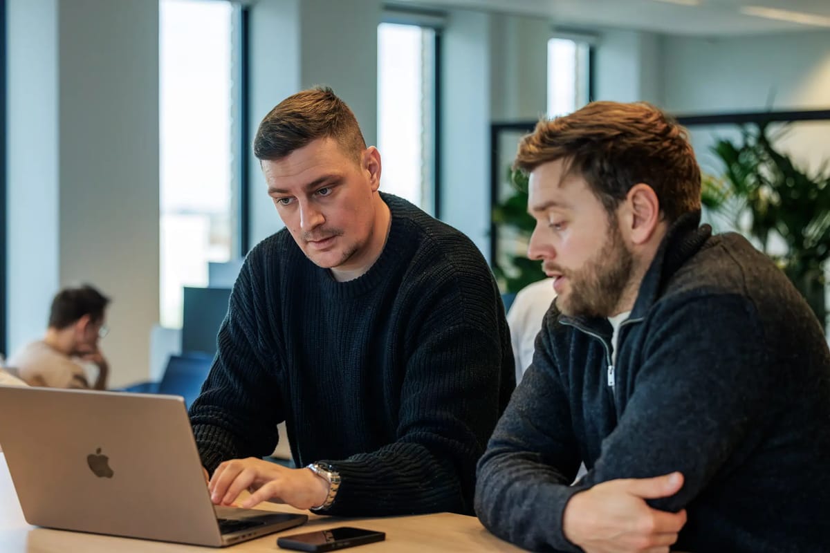 Zwei Kollegen aus dem Marketing- und Sales-Team im Gespräch am Schreibtisch