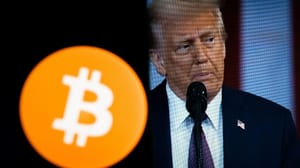 Een afbeelding van het bitcoin logo met daarnaast een afbeelding op een scherm van de president van de Verenigde Staten, Donald Trump Een afbeelding van het bitcoin logo met daarnaast een afbeelding op een scherm van de president van de Verenigde Staten, Donald Trump