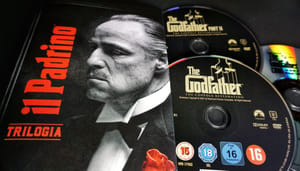 Een foto van verschillende cd's en verpakkingen van the godfather, een maffiafilm Een foto van verschillende cd's en verpakkingen van the godfather, een maffiafilm