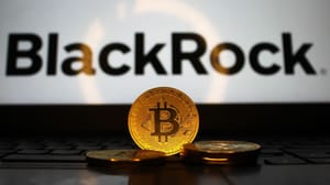 Een afbeelding van fysieke bitcoin munten voor een laptop met het BlackRock logo erop