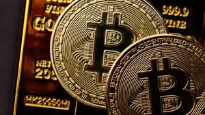 Een afbeelding van bitcoin (BTC) munten op goudstaven