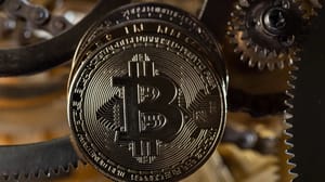 Een afbeelding van een bitcoin (BTC) munt bij een aantal gouden tandwielen Een afbeelding van een bitcoin (BTC) munt bij een aantal gouden tandwielen