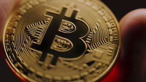 Een afbeelding van een bitcoin (BTC) die wordt vastgehouden, close-up die scherp inzoomt op de bitcoin