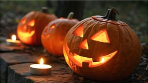 Een afbeelding van verlichte pompoenen waar enge gezichten in gesneden zijn voor Halloween