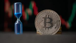 Een afbeelding van een bitcoin (BTC) munt met daarnaast een zandloper en op de achtergrond een grafiek van een volatiele koers Een afbeelding van een bitcoin (BTC) munt met daarnaast een zandloper en op de achtergrond een grafiek van een volatiele koers