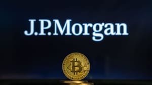 Een afbeelding van een bitcoin (BTC) munt met op de achtergrond het logo van JP Morgan, een van de grootste en belangrijkste banken ter wereld Een afbeelding van een bitcoin (BTC) munt met op de achtergrond het logo van JP Morgan, een van de grootste en belangrijkste banken ter wereld