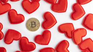 Een afbeelding van een bitcoin (BTC) munt tussen allemaal valentijn hartjes Een afbeelding van een bitcoin (BTC) munt tussen allemaal valentijn hartjes