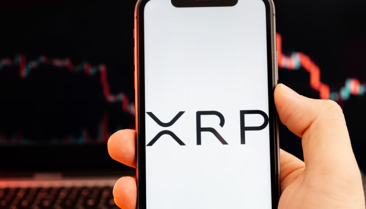 Een afbeelding van het prijspatroon van XRP met op de voorgrond het logo van de munt van Ripple Een afbeelding van het prijspatroon van XRP met op de voorgrond het logo van de munt van Ripple