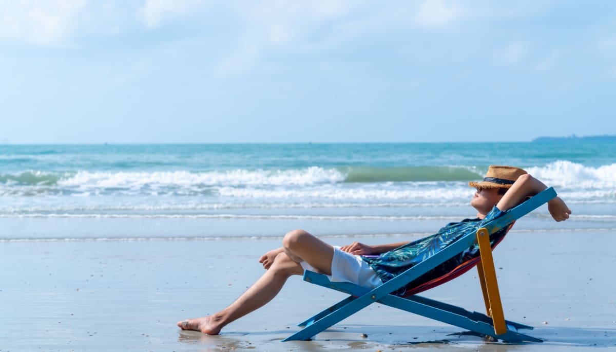 man-op-strand-chillen Man op strandstoel