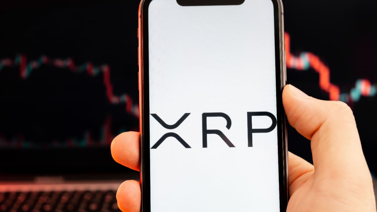 Een afbeelding van de cryptomunt XRP, met op de achtergrond een dalende koers Een afbeelding van de cryptomunt XRP, met op de achtergrond een dalende koers